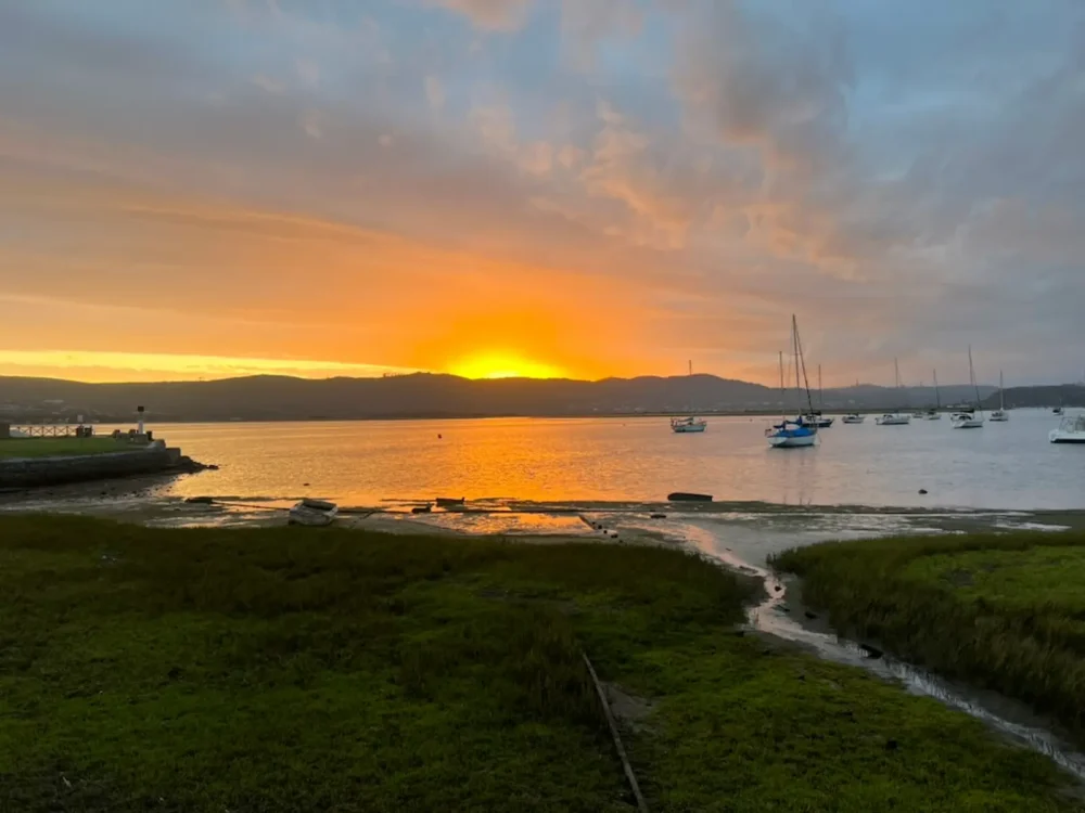 Sunset over Knysna Lagoon, South Africa, with sailboats and golden light on the water