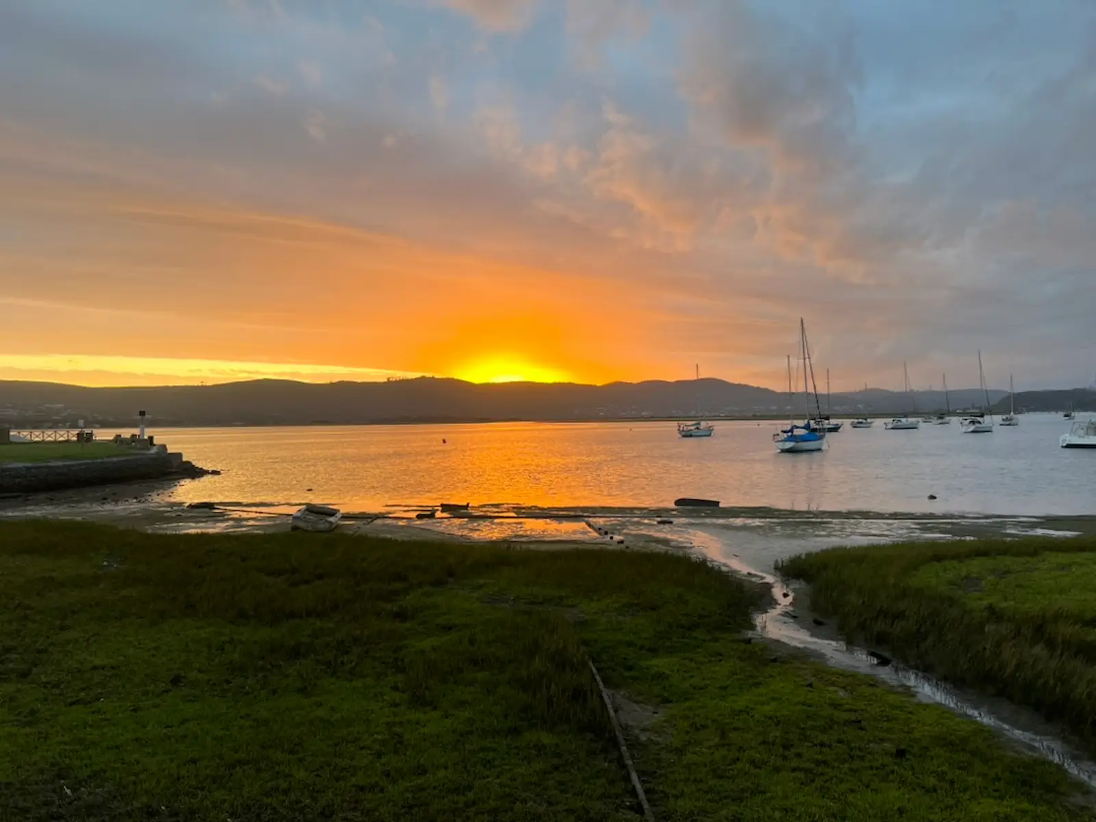 Sunset over Knysna Lagoon, South Africa, with sailboats and golden light on the water